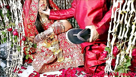 Desi Indian honeymoon bride in red saree kissed by groom