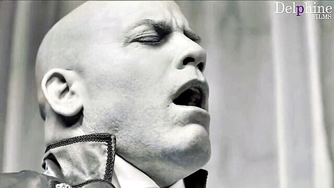 Dramatic black and white portrait of bald man in formal collar shouting, Delphine Films