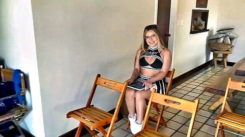 Smiling blonde cheerleader in sexy bikini top and skirt, back to school gangbang tease