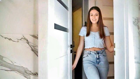 Brunette stepsister smiling in doorway, crop top and jeans tease