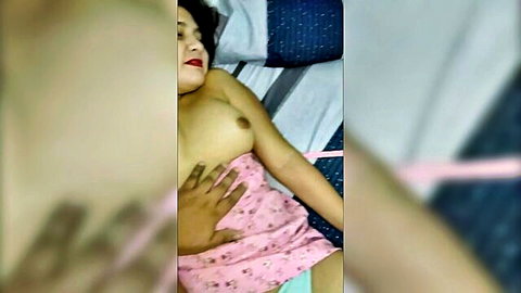 Asian woman exposing breast, hand groping tit in pink lingerie on bed