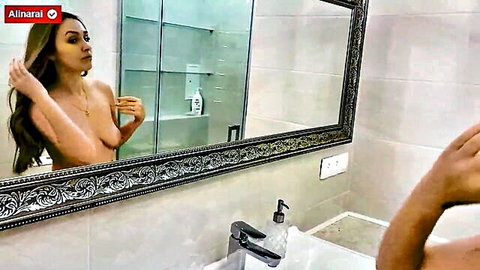 Nude stepmom posing topless in bathroom mirror, long wavy hair