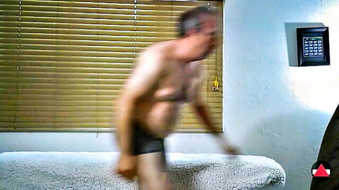 Blurry man in black underwear bending over couch in facesitting fetish video