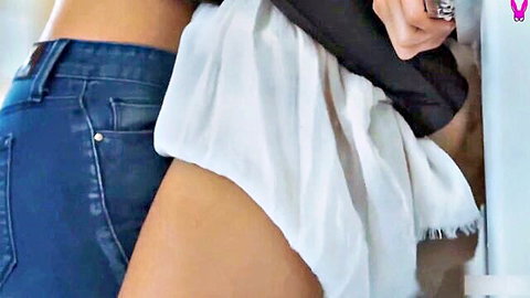 Sensual lesbians in intimate embrace, one in tight jeans, other in white skirt
