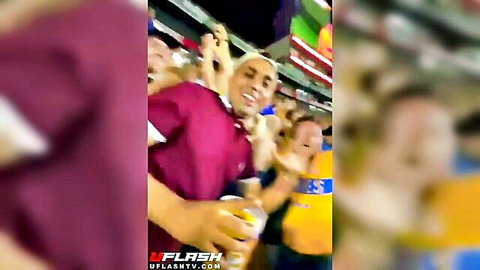 Excited crowd at soccer game, flashing in stadium cheers