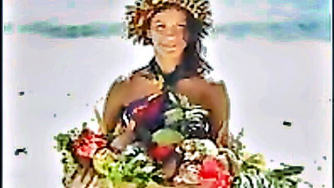 Eva Roberts in exotic tropical beach attire, smiling with floral bouquet