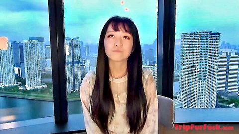 Asian woman in white blouse smiling in high-rise city view