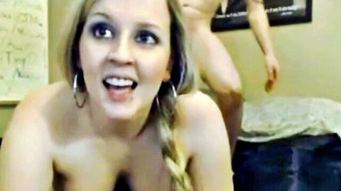 Busty blonde webcam girl smiling topless during intimate scene