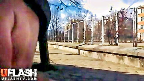 Amateur street flash: woman exposes bare ass outdoors by fence