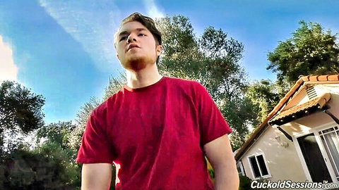 Young guy in red t-shirt looks up outdoors by house on cuckold site