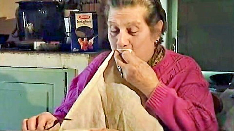 Mature Italian actress in pink cardigan eating cereal from box, 1994 scene with Rebecca Lord