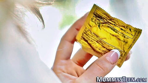 Blonde mature stepmom holding condom packet, teasing lesbian vibe