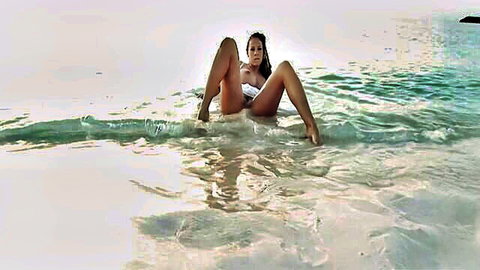 Gianna Michaels solo in wet white bikini on beach, legs spread seductively