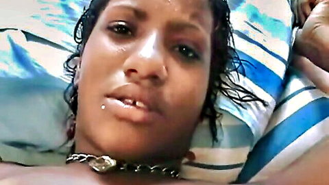 Tearful ebony woman topless, emotional expression on bed