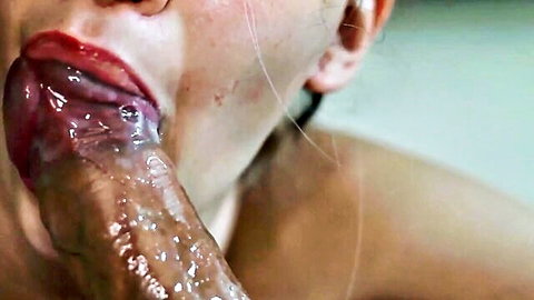 Woman's tongue licking thick cum-drenched cock with semen dripping on her lips