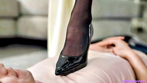 Lauren Phillips in black stockings and heels dominating submissive