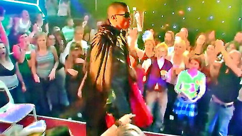 Bald stud performer on stage at wild amateur party cheered by hot crowd of women