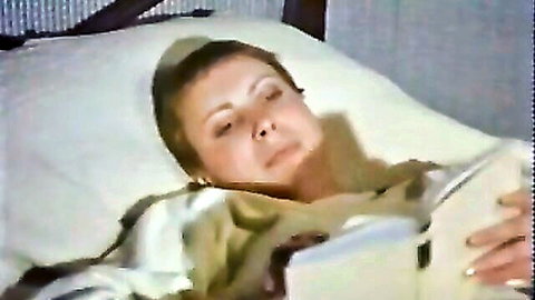 Vintage Italian actress relaxing in bed with book, seductive nightgown tease