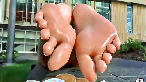 Shiny oiled bare feet soles up close outdoors glistening for foot worship fetish