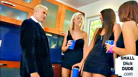 Three hot babes in tight black mini dresses surround older suited small dick dude holding drinks in kitchen