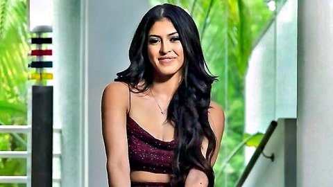 Sophia Leone smiling in sexy maroon strappy dress, long dark hair