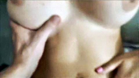 Man's hand gropes huge bare tits with pink nipples on curvy fair-skinned woman