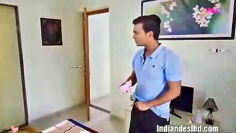 Indian man holding pink bra in bedroom with open door and bed