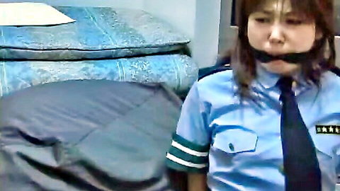 Bound Asian policewoman gagged in blue uniform, BDSM bondage scene