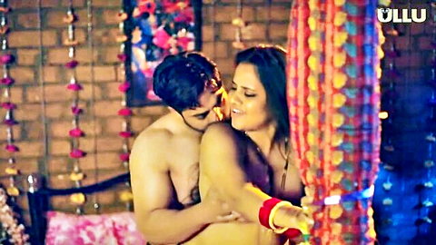 Topless Indian MILF with big tits passionately embraced and kissed on neck by shirtless muscular lover