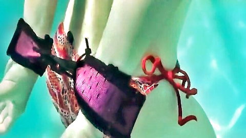 Underwater BDSM bondage with bound woman in purple bikini straps