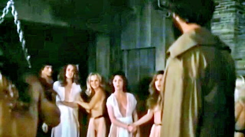 Group of topless women in white gowns circle in BDSM bondage ritual