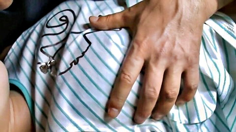 Marin Aono in striped shirt, hand touching side in BDSM JAV teaser