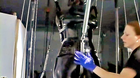 Woman in tight latex bondage suspended during BDSM fitness training