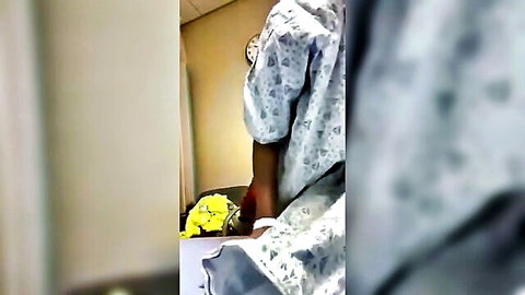 Ebony patient in hospital gown holding yellow flowers in ER quickie scene
