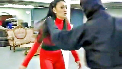 Masked man grabs Asian brunette in tight red latex outfit during intense struggle