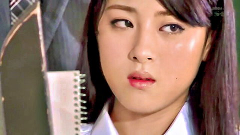 Seductive Japanese schoolgirl in uniform peeking over notebook with glossy lips teasing