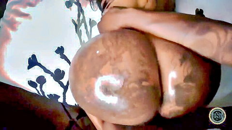 Ebony woman with massive oiled ass bent over in sexy pose