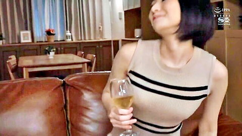 Asian woman in striped dress sipping wine seductively