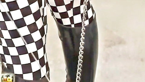BDSM woman in checkered leggings and chained black boots