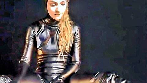 Blonde in full black latex catsuit with gag, BDSM pose