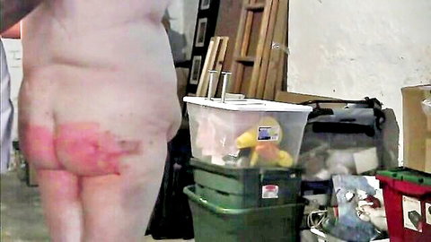 Naked curvy woman showing red-spanked ass in BDSM scene