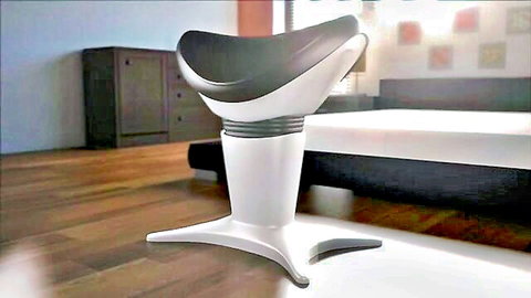 Modern black saddle stool on white base in bright bedroom interior