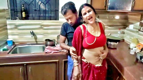 Indian MILF in red saree groped by man from behind in kitchen, exposed midriff and cleavage