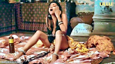 Seductive Indian woman in yellow outfit teasing on bed, Imli Ullu series
