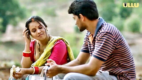 Sexy Indian woman in revealing saree blouse with deep cleavage flirts with man on motorcycle outdoors