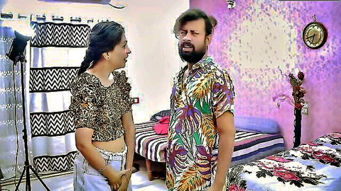 Sexy Indian brunette MILF in leopard top smiles at surprised guy in floral shirt in bedroom
