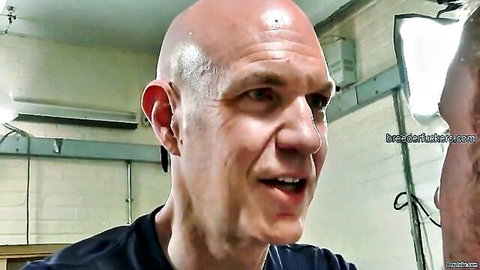 Bald Caucasian man in dark shirt, gay porn inspection scene