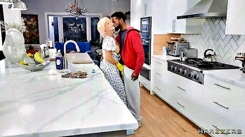 Blonde GILF in floral dress passionately kisses young black stud in kitchen