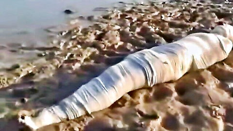Mummified submissive wrapped in bandages buried in mud BDSM