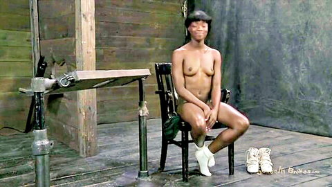 Nude very dark-skinned black slave girl in BDSM pose, socks and boots